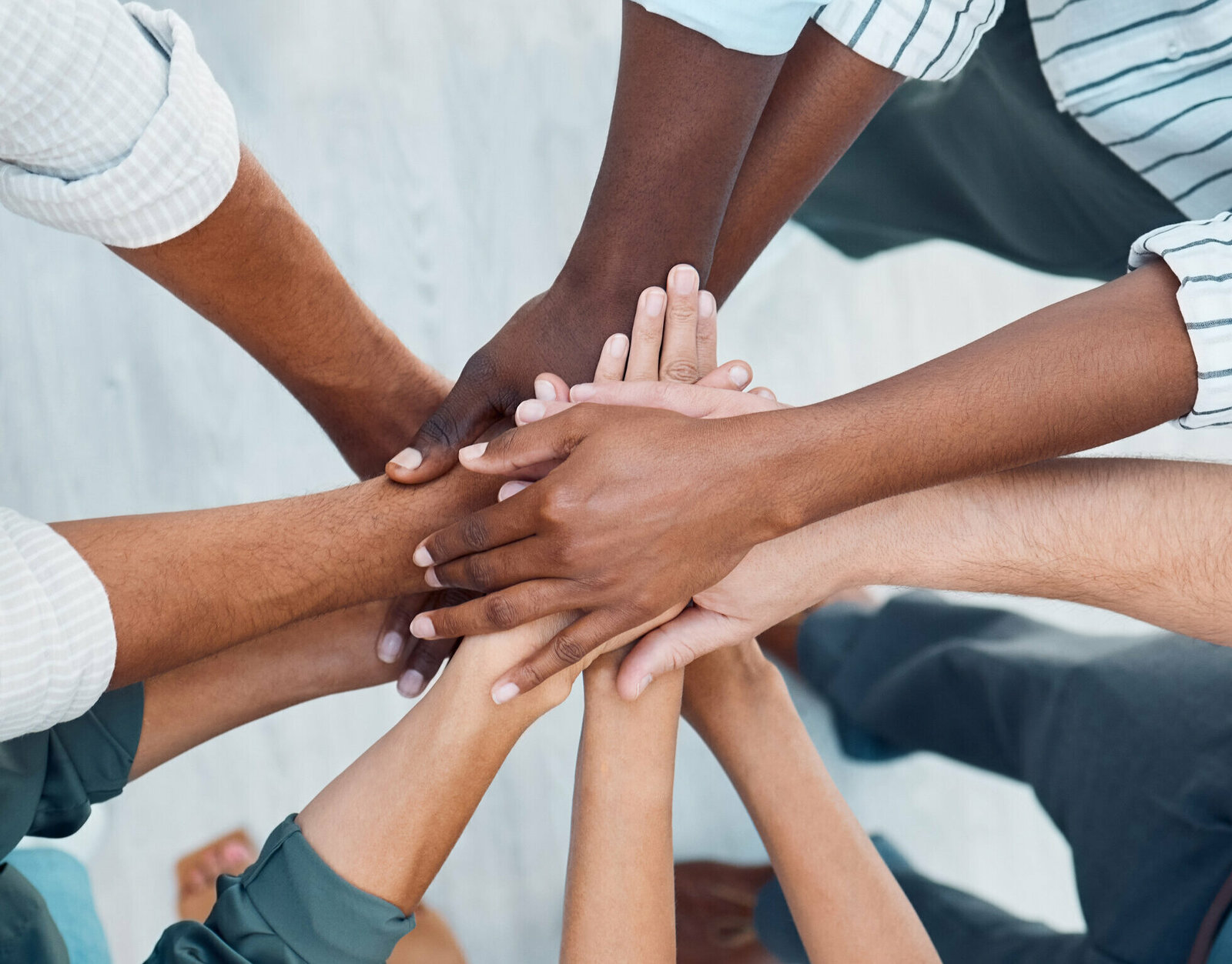 Diversity, hands and team above in support, trust and unity for collaboration, agreement or meeting at the office. Group hand of diverse people in teamwork, cooperation and solidarity for community